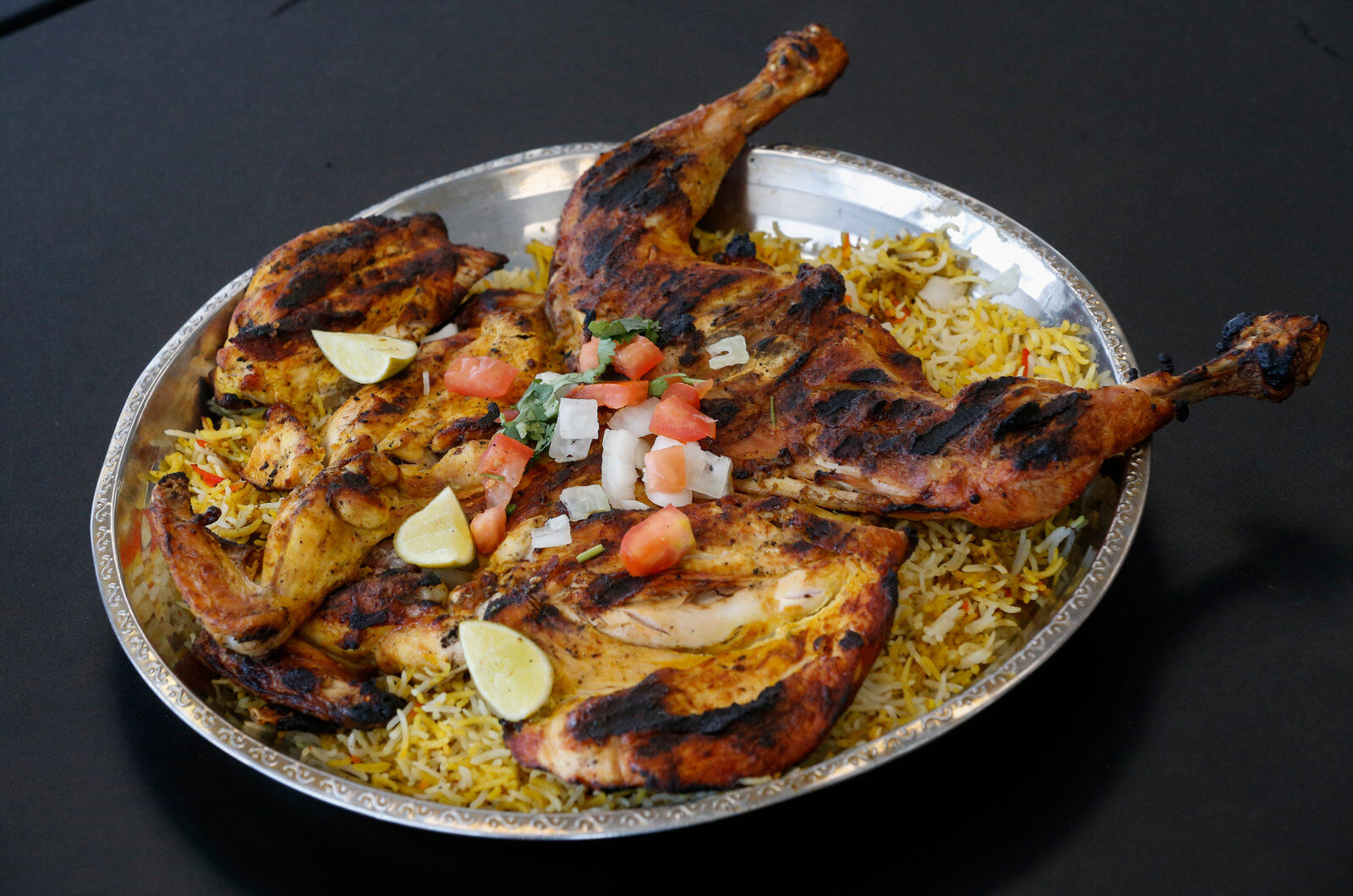 Whole grilled chicken over rice with salsa at Almandi Restaurant
